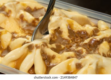 Close-up Of Scooping Caramel Ice Cream With A Dessert Spoon. Macro Photography Of Ice Cream With Caramel.