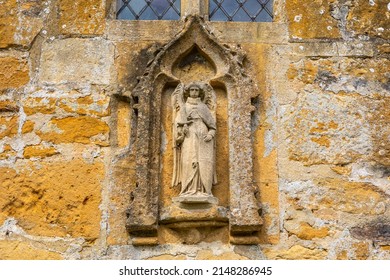 Close-up of a sculpture on the exterior of the Church of St. Michael and All Angels in the village of Stanton in Gloucestershire, UK.