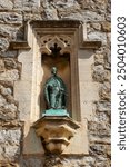 Close-up of a sculpture of St. Clement of Rome, on the exterior of St. Clements Church in Leigh-on-Sea, Essex, UK.