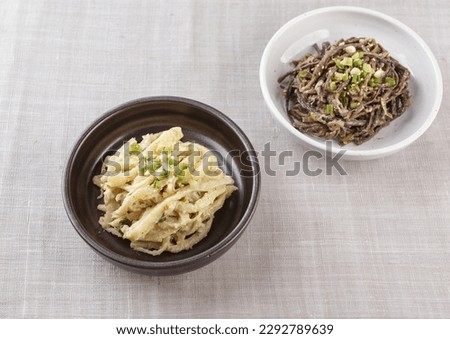 Close-up of seasoned balloon flower root and seasoned bracken on two dishes and cloth, South Korea
