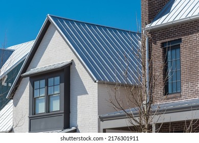 Close-up Second Floor Of Brand New House With Metal Roof And Covered Gutter Near Oklahoma City, US. Modern Two Story Townhouse With Bay Windows And Thin Brick Siding Sunny Winter Day Blue Sky