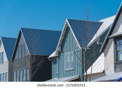 Close-up Second Floor Of Brand New House With Metal Roof And Covered Gutter Near Oklahoma City, US. Modern Two Story Townhouse With Bay Windows And Thin Brick Siding Sunny Winter Day Blue Sky