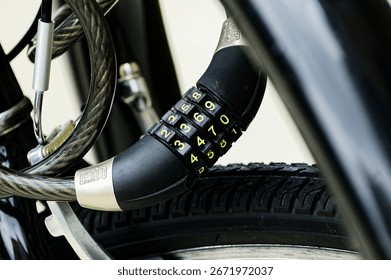 Close-Up of Secure Bicycle Lock with Numeric Combination on Sturdy Tire. Bicycle lock wrapped securely around sturdy tire features numeric combination lock. Close-up image highlights important