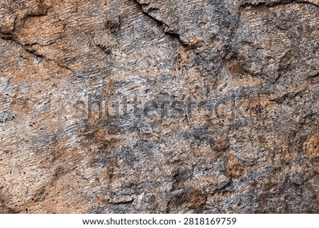 Close-up of sedimentary rock surface featuring natural striations, gray and brown tones, and rough texture. Ideal natural stone background for graphic design, architecture, geology, construction, and abstract compositions.
