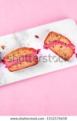 A close-up of a seed cake with ruby chocolate, shot from the top on a pink background with a place for text
