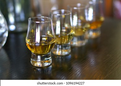 Close-up / Selective Focus A Flight Of Whiskies. Four Different Whiskies In Whisky Tasting Glasses.