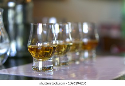 Close-up / Selective Focus A Flight Of Whiskies. Four Different Whiskies In Whisky Tasting Glasses.