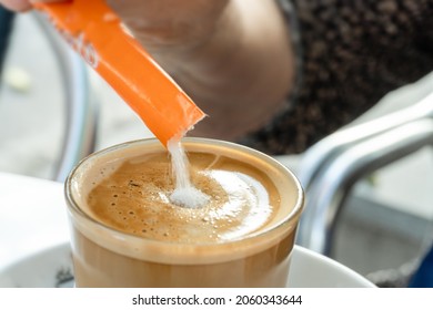 Close-up with selective focus pouring sugar to a latte. - Powered by Shutterstock