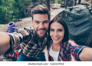 Close-up self-portrait of adorable nice lovely trendy cheerful spouses people on honeymoon vacation trip, wearing casual checkered shirts in wild wood - Powered by Shutterstock