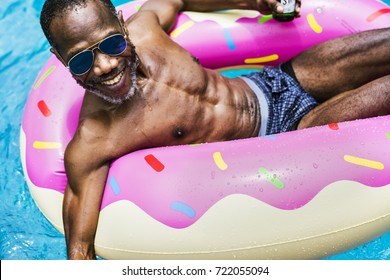 Closeup Of Senior African Descent Man Floating In The Pool With In Flatabel Tube