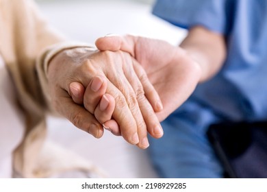 Close-up Senior Asian Woman Hand With Her Caregiver Helping Hands Holding Together, Caregiver Visit At Home. Home Health Care And Nursing Home Concept.