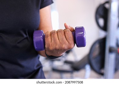 Close-up Of Senior Black Woman Lifting Dumbbell In Gym For Health And Fitness.