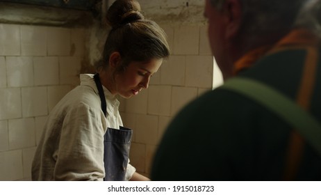 Closeup Senior Ceramist Teaching Girl In Workshop. Portrait Of Excited Woman Listening Teacher In Studio. Elderly Artist Controlling Sculpting Process In Pottery.