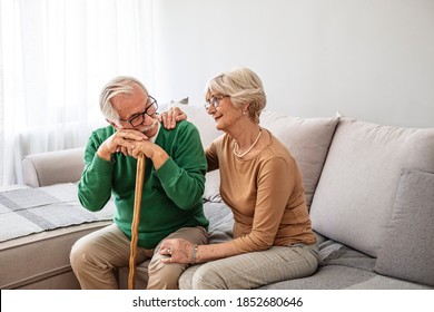 Closeup of senior couple hands holding walking stick. Old husband and wife holding cane handle while looking at each other. Happy retired couple joining hands with love at home. - Powered by Shutterstock