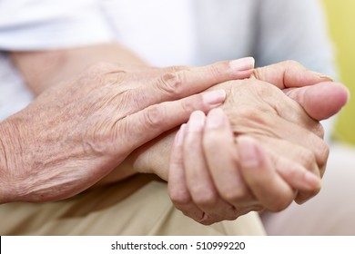 el primer plano de las manos de un anciano que toca acariciar la mano de una anciana
