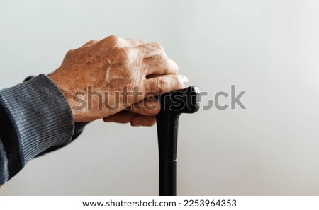 Closeup of senior man hands on canes. Elderly loneliness. Elderly care. Concept of health caring for elderly old people, disabled.