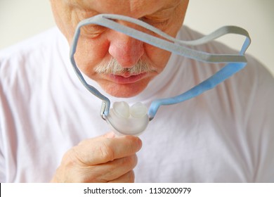 Closeup Of Senior Man With The Headgear Portion Of A Continuous Positive Airway Pressure Machine For Sleep Apnea