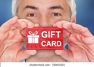 Close-up Of A Senior Man Holding Red Gift Card