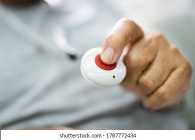 Close-up Of Senior Man Pressing Alarm Button For Emergency