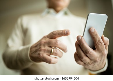 Close-up Of Senior Man Using Mobile Phone Indoors. 