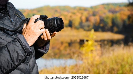 Close-up senior woman holding digital camera taking photo of autumn landscape outdoors, copy space. Side view of female photographer against backdrop of forest and lake. Elderly people and technology. - Powered by Shutterstock