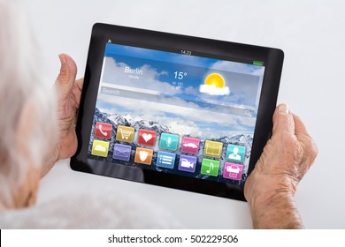 Close-up Of Senior Woman Holding Digital Tablet Showing App On Display