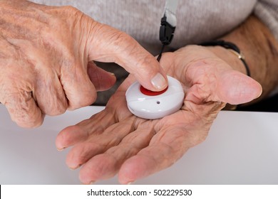 Close-up Of Senior Woman Pressing Alarm Button For Emergency