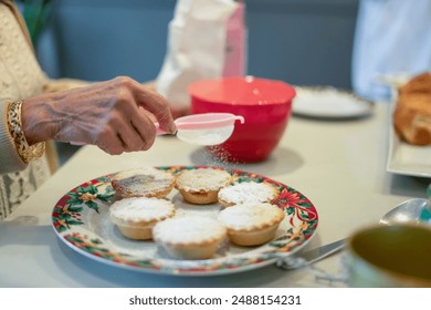 Close-up of senior woman sprinkling powdered sugar on cupcakes - Powered by Shutterstock