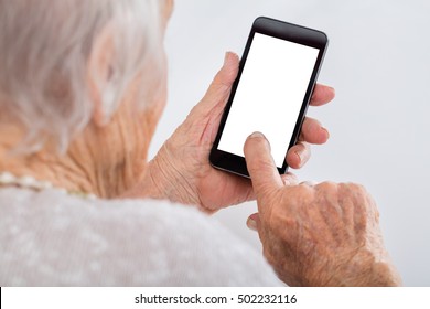 Close-up Of Senior Woman Using Smartphone With Blank Screen At Home