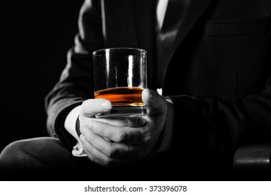 Closeup of serious businessman holding  whiskey illustrate executive privilege concept.  - Shutterstock ID 373396078