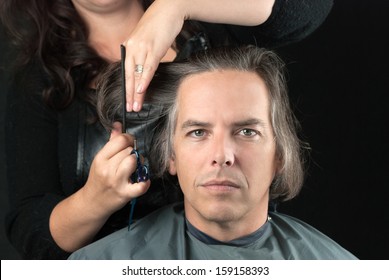 Close-up Of A Serious Man Looking To Camera While His Long Hair Is Cut Off For A Cancer Fundraiser.