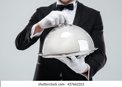 Closeup Of Serving Tray With Metal Cloche Holded By Butlers Hands In Gloves