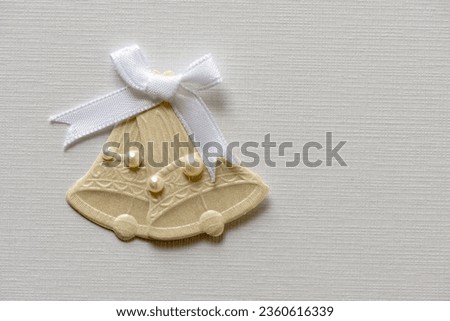 close-up of a set of card crafting wedding bells with ribbon isolated with space on textured paper