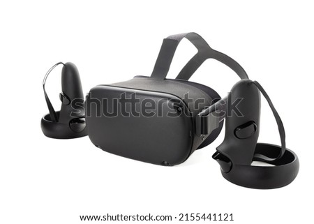 Close-up of a set of virtual reality devices. Joysticks and VR glasses isolated on a white background. Two controllers and a VR helmet. Side view