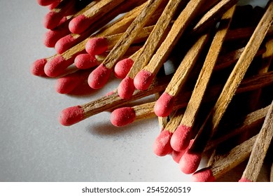 Close-up of several old matchsticks with red tips and sticks scattered across a smooth granite surface. - Powered by Shutterstock