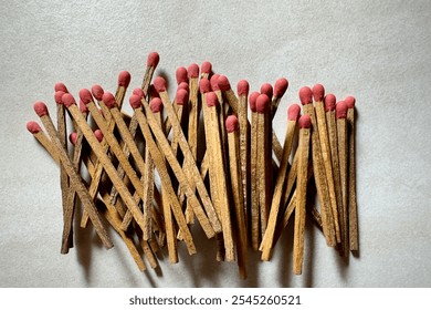 Close-up of several old matchsticks with red tips and sticks scattered across a smooth granite surface. - Powered by Shutterstock