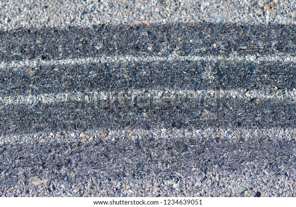 Close-up of several\
tire skid marks on\
asphalt