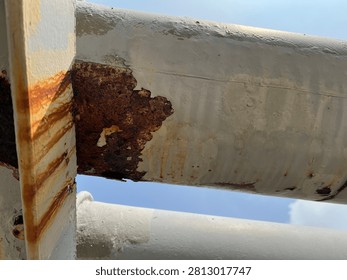 Close-up of severe external corrosion developing at the contact point between a steel pipeline and its structural support. Extensive coating failure and rust formation illustrate corrosion under support (CUS), asset deterioration, inspection, maintenance, and industrial integrity management in process facilities.