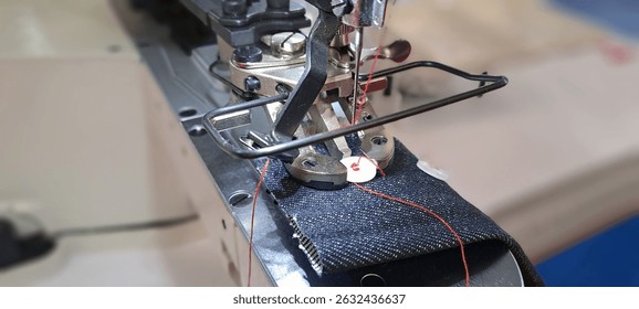 Close-up of sewing machine attaching button to denim, showcasing precision and automation in garment industry