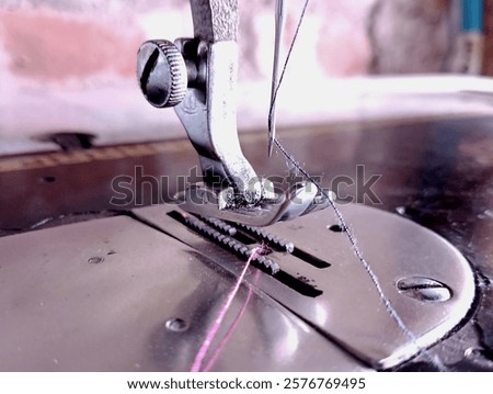 Close-up of a sewing machine needle threading mechanism, showcasing precision craftsmanship and industrial design, symbolizing the art of tailoring and garment creation.