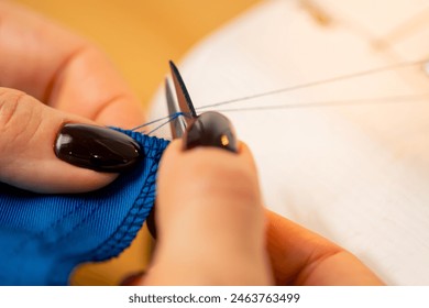 close-up in a sewing workshop scissors for working on fabric cut off blue thread