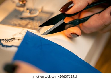 close-up in a sewing workshop scissors for working on fabric cut off blue thread