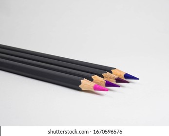 Close-up Of Sharp Coloured Pencils Pink And Shades Of Purple And Violet. 4 Coloured Pencil Tips. Drawing And School Supplies.