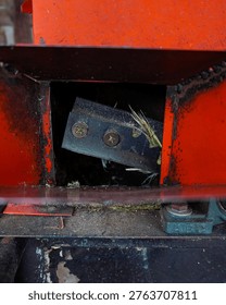 Close-up of sharp cutting blade inside a grass chopper machine, agricultural equipment detail with industrial metal texture.