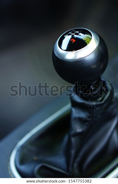 closeup\
of the shift knob of a manual transmission\
car.