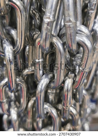 Close-up of shiny metal chains with interlinked steel texture, industrial strength, and detail