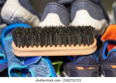 A Closeup Of A Shoe Brush On Different Footwear