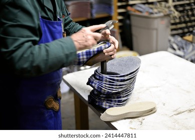 Close-up of shoemaker working on slippers in workshop - Powered by Shutterstock