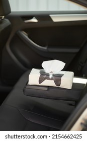 Close-up Shoot Of A Black Cat Tissue Box In A Black Car. The Tissue Box With A White Paper Tissue For Cars Is Isolated On A Black Background. Top View.