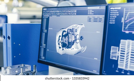 Close-up Shot of the 3D CAD Model of the Engine Shown on Computer Screen. In the Background Manufacturing Factory with People Working.